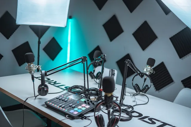 Sleek podcast studio setup featuring microphones, audio mixer, and acoustic panels. Audio-Kampagnen abwickeln